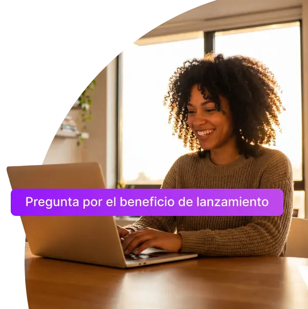 Mujer sonriente de cabello rizado trabajando en un portátil, imagen de los programas virtuales de EAFIT