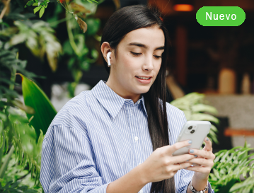 Mujer con audífono revisando su celular entre plantas: diplomado virtual de artes y humanidades EAFIT Virtual